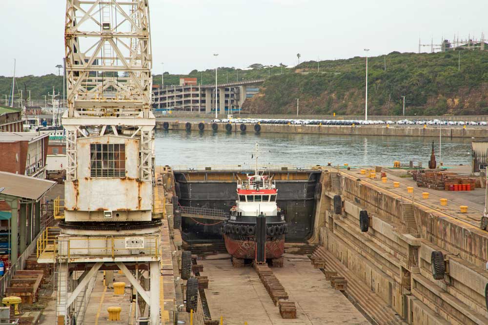 East London harbour dry dock facility showing vessel under repair with industrial crane and maritime infrastructure