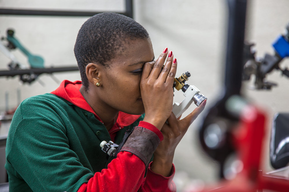 Diamond grading specialist examining gemstone with precision loupe showing detailed quality assessment techniques