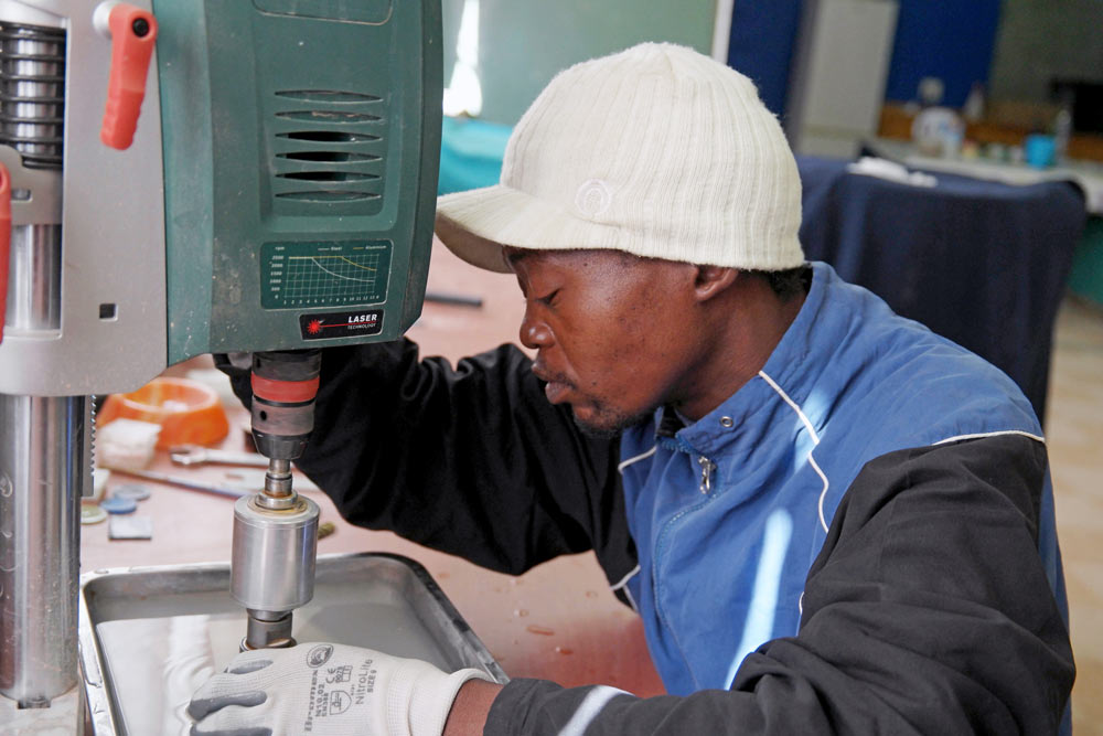 Workshop participant using laser cutting equipment during skills training at disability empowerment project Kimberley