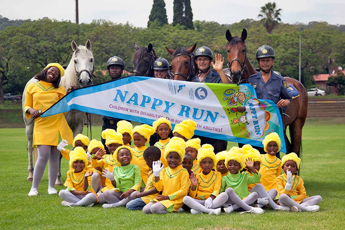 SAPS mounted police officers on horses posing with drum majorettes in yellow uniforms at a Pretoria event